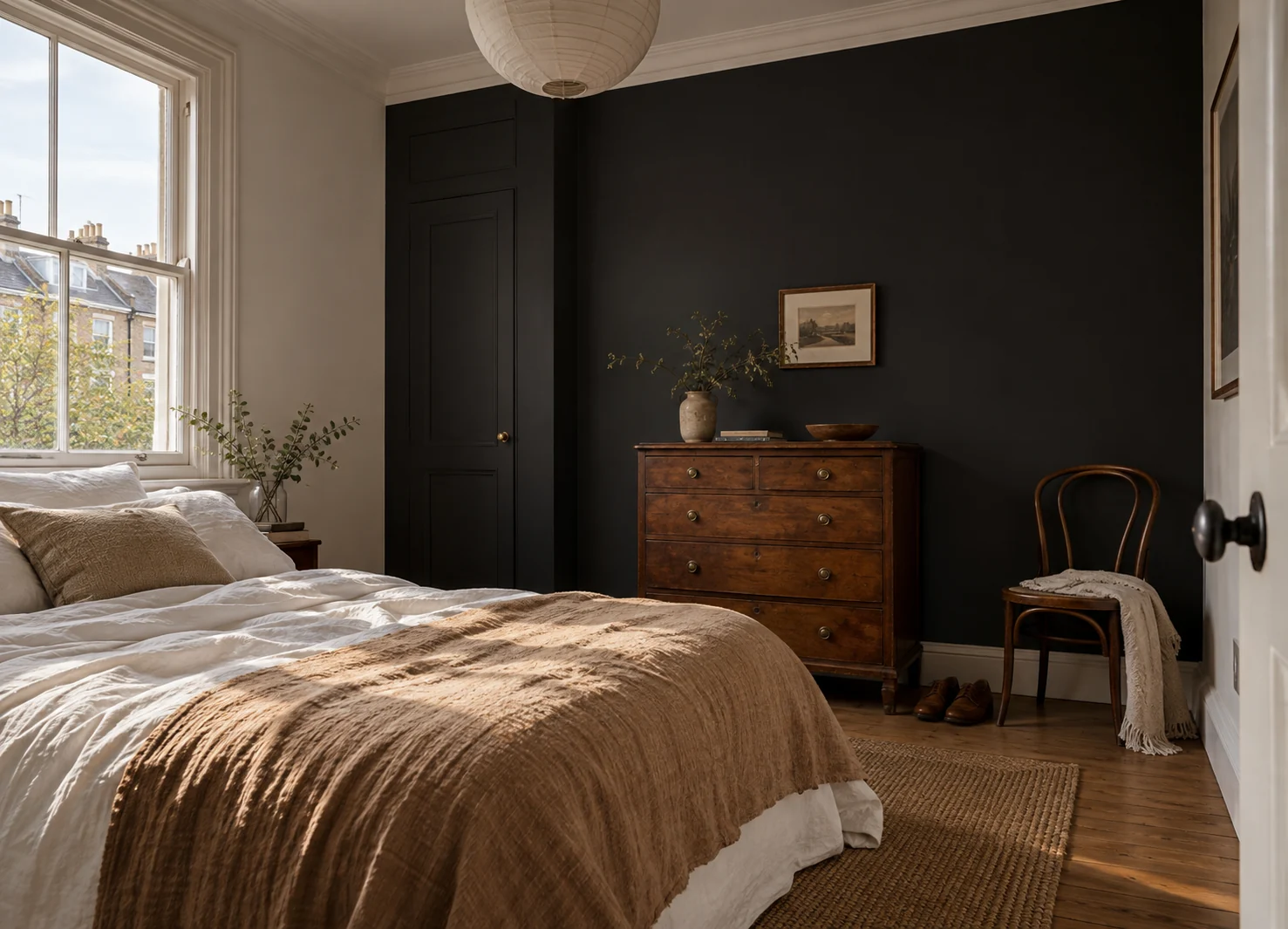 Bedroom with dark walls beside a window and light bedding